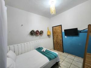 a room with a bed and a tv and a room with a bed sidx sidx at Mini Hostel in Tutóia