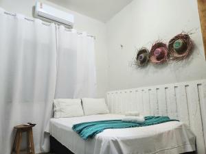 a bedroom with a bed with a radiator and two baskets at Mini Hostel in Tutóia