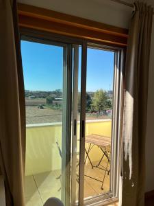 een glazen schuifdeur met uitzicht op een veld bij Alojamento Local Pando in Aveleda