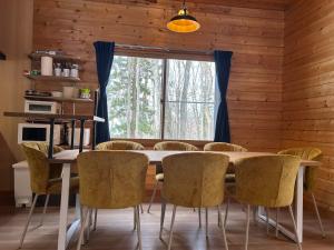 a dining room with a table and chairs and a window at Pebble Mountain Cabin in Shinano