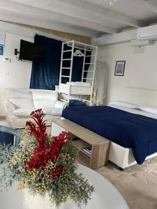 una camera da letto con un letto e un divano di B&B Villa Mediterranea with parking space a Trani