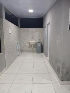 ein Zimmer mit einem Badezimmer mit Waschbecken und gefliester Wand in der Unterkunft Kitnet na mata atlantica in Ubatuba