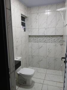 ein Badezimmer mit Toilette und gefliester Wand in der Unterkunft Kitnet na mata atlantica in Ubatuba