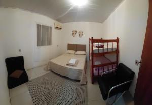 a small room with a bed and two chairs at Pousada do Coqueiro in São Gabriel
