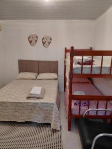 a bedroom with two bunk beds and a shelf at Pousada do Coqueiro in São Gabriel +4 photos
