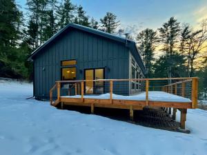 una piccola baita con un ponte nella neve di White Pine Chalet a Yulan