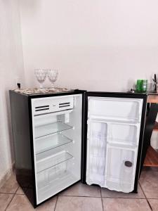 een open koelkast met daarin twee wijnglazen bij Suíte 2 Completa - Wi-Fi e Netflix in Jundiaí
