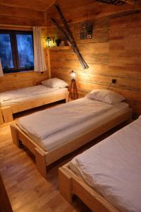 zwei Betten in einem Zimmer mit Holzwänden in der Unterkunft Osada Brzeziny - 25 minut od Warszawy - sauna, balia z jacuzzi, basen, altana, grill, ogród, ognisko in Brzeziny + 15 Fotos
