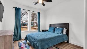 a bedroom with a bed with a blue comforter and a window at Texoma Elegance in Kingston
