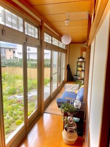 un soggiorno con finestre e divano di 五縁箱 a Hannan