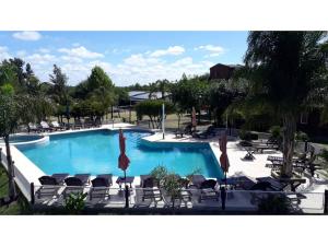 a large swimming pool with chairs and a resort at Cabañas Villa Fariña in Gualeguaychú +9 photos