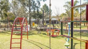 a playground with a red ladder in a park at Cabañas Villa Fariña in Gualeguaychú
