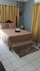 een slaapkamer met een groot bed en gele gordijnen bij Snuggled Oasis Studio in Portmore