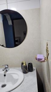 een badkamer met een wastafel en een spiegel bij Appartement avec Terrasse in Larache