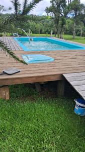 eine Holzterrasse neben einem Pool in der Unterkunft Refúgio Serrano in São Francisco de Paula