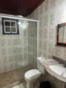 a bathroom with a toilet and a sink and a shower at Pousada Arco íris na Serra in Tiradentes +50 photos