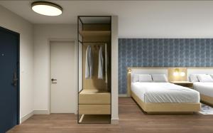 a bedroom with a bed and a closet at Hotel Kelowna & Conference Centre in Kelowna