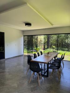 a dining room with a wooden table and chairs at Recanto Rivière in Guarapuava