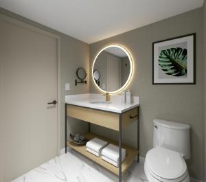 a bathroom with a sink and a mirror at Hotel Kelowna & Conference Centre in Kelowna