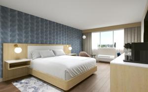 a bedroom with a bed and a tv in a room at Hotel Kelowna & Conference Centre in Kelowna +3 photos