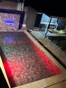 a swimming pool with a red and blue liquid in it at Hospedaje el Argentico in Tapantí +7 photos
