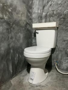 een badkamer met een wit toilet in een kamer bij Phayam Hostel in Ko Phayam
