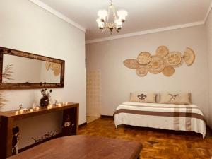 a bedroom with a bed and a mirror and a table at Pousada Arco íris na Serra in Tiradentes
