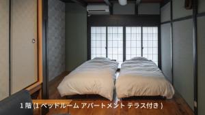 twee kussens op een bed voor een spiegel bij 宿すごろく in Nagahama