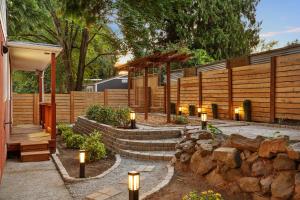 a backyard with a fence and lights and a stone wall at Seattle cottage in Seattle