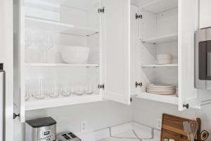 a kitchen with white cabinets with glassware at Casa Yano by The Beach in Santa Barbara +169 photos