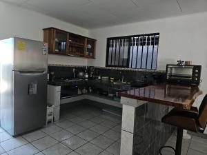 a kitchen with a stainless steel refrigerator and a counter at Casa Burbujas in Puerto Jiménez