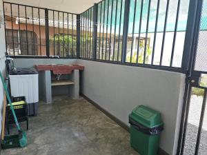 een kamer met een hek en een vuilnisbak bij Casa Burbujas in Puerto Jiménez