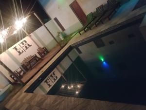 an empty swimming pool at night with chairs and lights at Complejo la Raquel in Goya +8 photos