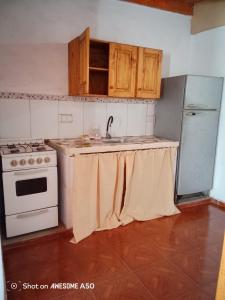a kitchen with a sink and a stove and cabinets at Complejo la Raquel in Goya