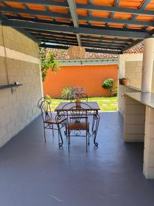 a patio with a table and two chairs on a patio at Pousada Arco íris na Serra in Tiradentes