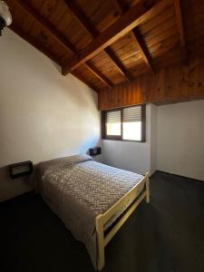 une chambre avec un lit dans une pièce avec des plafonds en bois dans l'établissement Duplex amplio y tranquilo 3habs 2baños, à San Bernardo