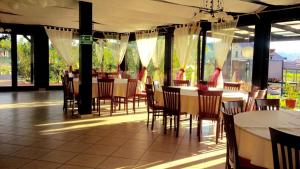 a dining room with tables and chairs and windows at Casa Salcia Oituz in Oituz