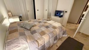 een slaapkamer met een groot bed en een televisie bij Casa Alisella in Milaan
