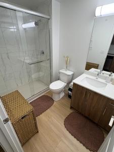 een badkamer met een toilet, een wastafel en een douche bij Boho Studio Downtown Rogers Views Heated PK in Edmonton +20 foto's