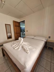 een slaapkamer met een bed met witte handdoeken bij Casa Burbujas in Puerto Jiménez