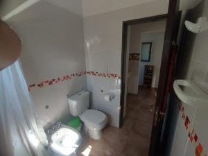 ein Badezimmer mit weißer Toilette und Waschbecken in der Unterkunft Casa moderna con pileta in Bialet Massé + 11 Fotos