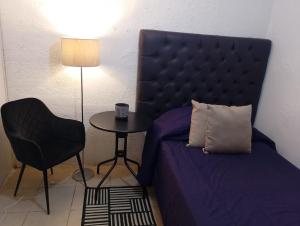 a bedroom with a bed and a table with a chair at Loft en Casa Jasso! in Guanajuato