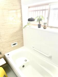 un bagno bianco con vasca e lavandino di 五縁箱 a Hannan