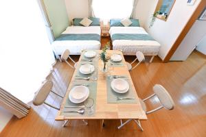 a dining room with a table and two beds at 民泊 Ichinomiya K Room 2B in Ichinomiya