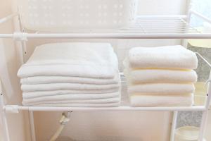 a stack of towels on a shelf in a bathroom at 民泊 Ichinomiya K Room 2B in Ichinomiya +23 photos