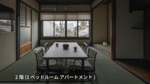 een eetkamer met een tafel en stoelen en een raam bij 宿すごろく in Nagahama +6 foto's