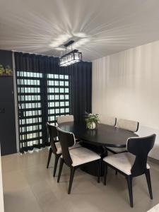 a dining room with a black table and chairs at New House Near The Beach in Ensenada +4 photos