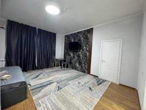 奇姆肯特Grand RR的客房设有一张床和一张桌子及一台电视