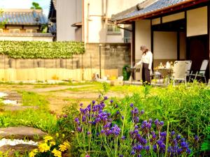 a person standing in a garden with a table at 五縁箱 in Hannan