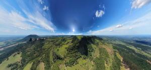 une vue aérienne d'une montagne verte sous un ciel nuageux dans l'établissement Casa das Cachoeiras, à Botucatu